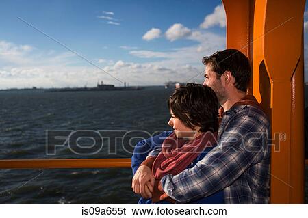 Couple hugging on ferry in urban harbor View Large Photo Image Stock Photograph - Couple hugging on ferry in urban harbor. Fotosearch