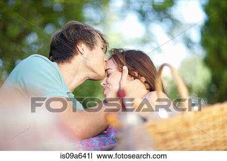 Stock Image - Couple kissing in park. Fotosearch