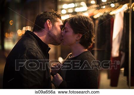Couple kissing on city street at night View Large Photo Image Stock Image - Couple kissing on city street at night. Fotosearch