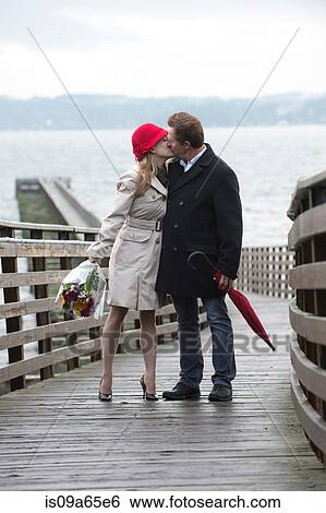 Stock Photograph - Couple kissing on wooden dock. Fotosearch