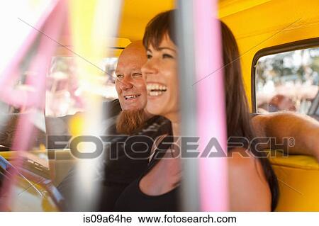 Couple laughing in colorful car View Large Photo Image Stock Image - Couple laughing in colorful car. Fotosearch