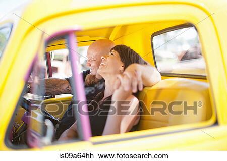 Couple laughing in colorful car View Large Photo Image Stock Image - Couple laughing in colorful car. Fotosearch