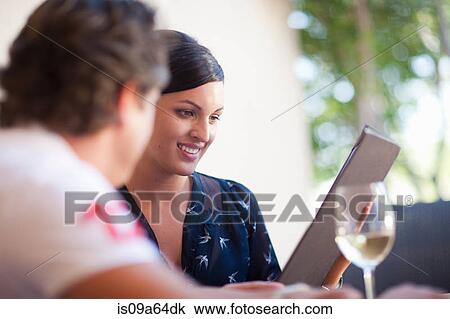 Stock Image - Couple reading menu in restaurant. Fotosearch
