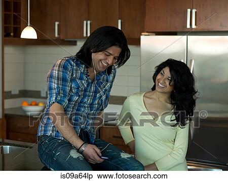 Stock Photography - Couple relaxing in kitchen. Fotosearch