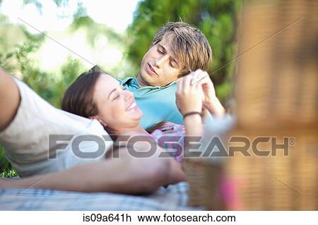 Couple relaxing on picnic blanket View Large Photo Image Stock Image - Couple relaxing on picnic blanket. Fotosearch