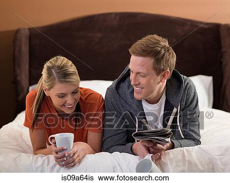 Stock Photograph - Couple relaxing together on bed. Fotosearch