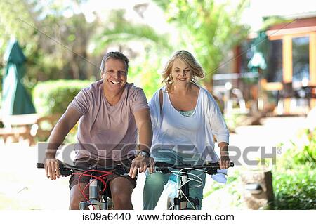 Couple riding mountain bikes together View Large Photo Image Stock Image - Couple riding mountain bikes together. Fotosearch