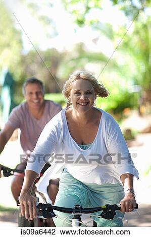 Couple riding mountain bikes together View Large Photo Image Stock Image - Couple riding mountain bikes together. Fotosearch