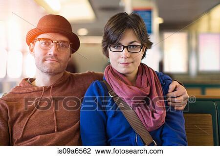 Stock Image - Couple siting on bench together. Fotosearch