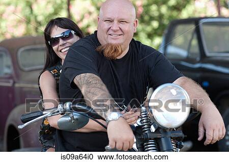 Stock Image - Couple sitting on motorcycle. Fotosearch
