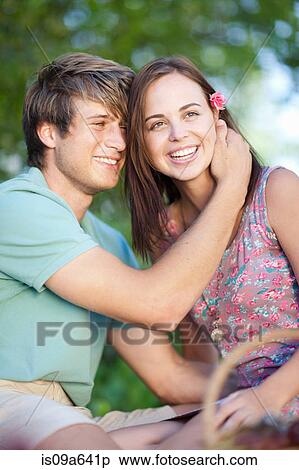 Stock Photography - Couple sitting on picnic blanket. Fotosearch