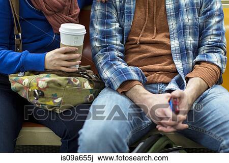 Stock Image - Couple sitting on urban subway. Fotosearch