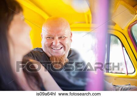 Stock Image - Couple smiling in colorful car. Fotosearch