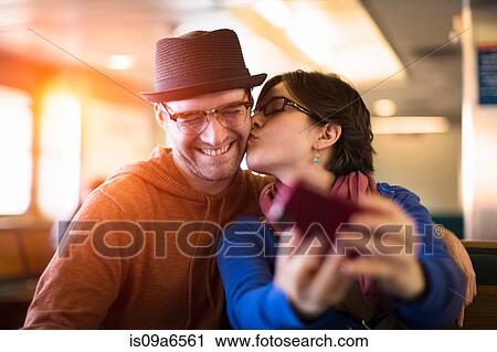 Stock Image - Couple taking picture with cell phone. Fotosearch