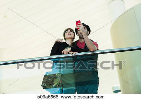 Stock Photograph - Couple taking picture with cell phone. Fotosearch