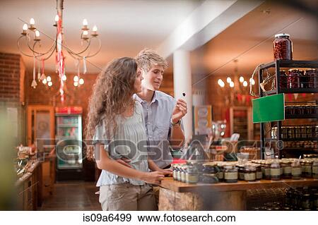 Couple tasting olives in grocery View Large Photo Image Stock Photo - Couple tasting olives in grocery. Fotosearch