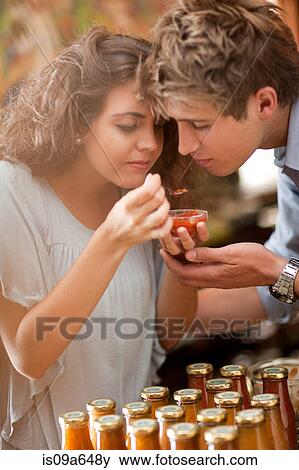 Couple tasting preserves in grocery View Large Photo Image Stock Photo - Couple tasting preserves in grocery. Fotosearch