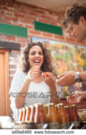 Stock Photography - Couple tasting preserves in grocery. Fotosearch
