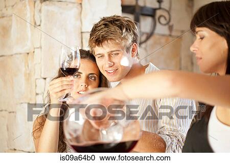 Stock Image - Couple tasting wine in doorway. Fotosearch