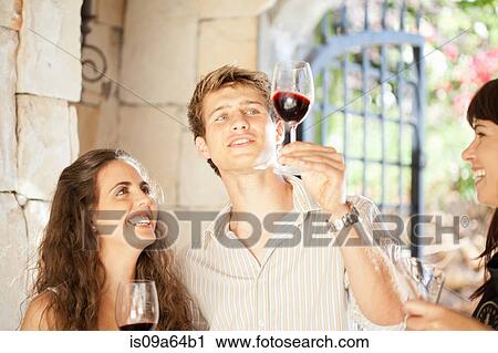 Stock Image - Couple tasting wine in doorway. Fotosearch