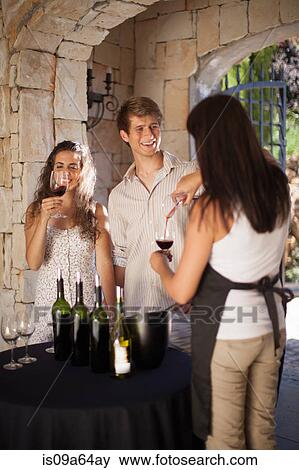 Stock Photo - Couple tasting wine in doorway. Fotosearch
