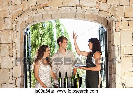Stock Photography - Couple tasting wine in doorway. Fotosearch