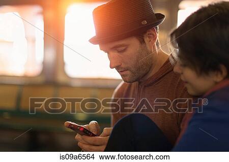 Couple using cell phone together View Large Photo Image Picture - Couple using cell phone together. Fotosearch