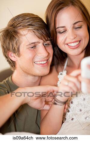 Couple using cell phone together View Large Photo Image Stock Image - Couple using cell phone together. Fotosearch