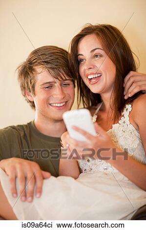 Couple using cell phone together View Large Photo Image Stock Image - Couple using cell phone together. Fotosearch
