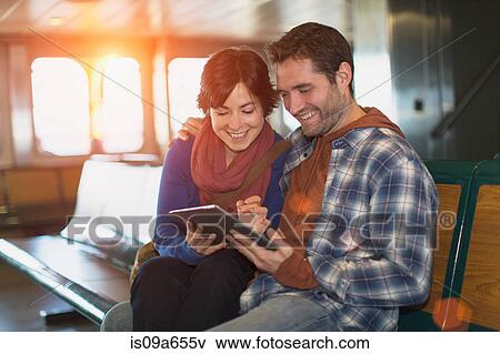 Couple using tablet computer on ferry View Large Photo Image Stock Photo - Couple using tablet computer on ferry. Fotosearch
