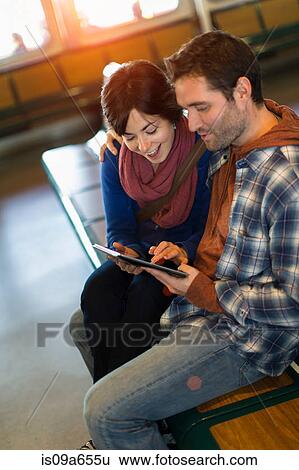 Stock Photograph - Couple using tablet computer on ferry. Fotosearch