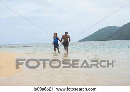 Couple walking on tropical beach View Large Photo Image Stock Image - Couple walking on tropical beach. Fotosearch