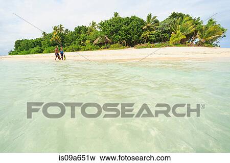 Stock Photo - Couple walking on tropical beach. Fotosearch