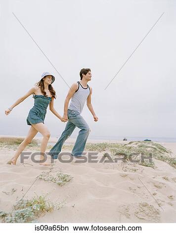 Picture - Couple walking together on beach. Fotosearch