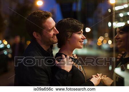 Stock Image - Couple window shopping on city street. Fotosearch