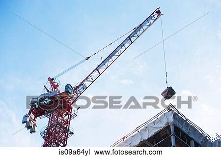 Stock Image - Crane loading equipment on building. Fotosearch