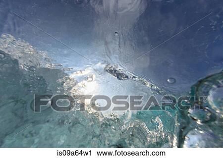 Stock Image - Crashing wave viewed underwater. Fotosearch