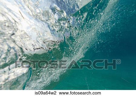 Stock Image - Crashing wave viewed underwater. Fotosearch