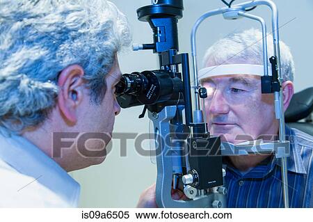 Stock Photography - Doctor giving patient eye exam. Fotosearch