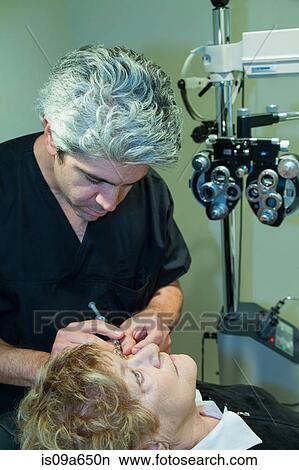 Doctor giving patient eye injection View Large Photo Image Picture - Doctor giving patient eye injection. Fotosearch