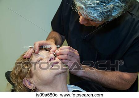Doctor giving patient eye injection View Large Photo Image Picture - Doctor giving patient eye injection. Fotosearch