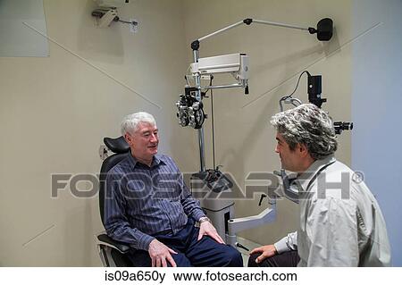 Stock Photo - Doctor talking to patient in office. Fotosearch