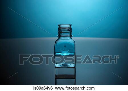 Stock Photograph - Drop splashing in glass bottle. Fotosearch