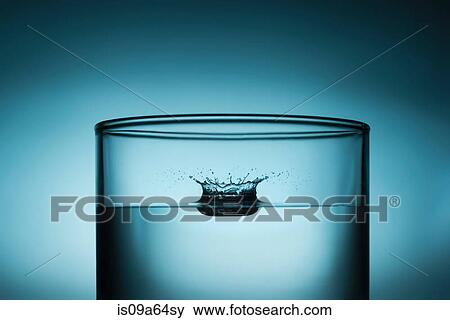 Drop splashing in glass of water View Large Photo Image Stock Photo - Drop splashing in glass of water. Fotosearch