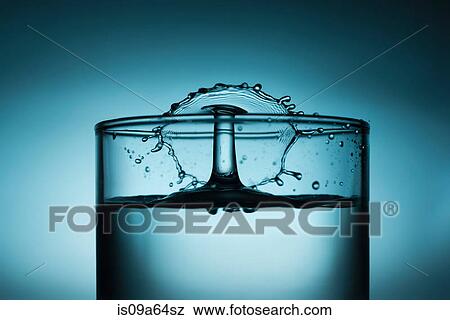 Drop splashing in glass of water View Large Photo Image Stock Photo - Drop splashing in glass of water. Fotosearch