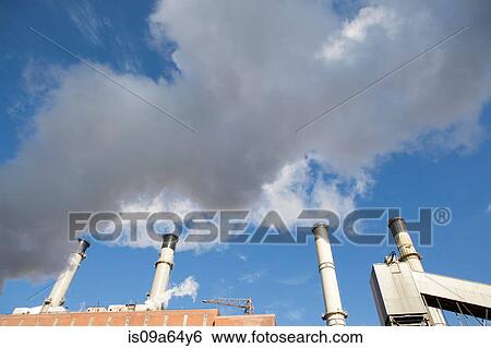 Factory smokestacks against blue sky View Large Photo Image Stock Photograph - Factory smokestacks against blue sky. Fotosearch