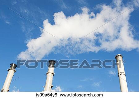 Stock Photography - Factory smokestacks against blue sky. Fotosearch