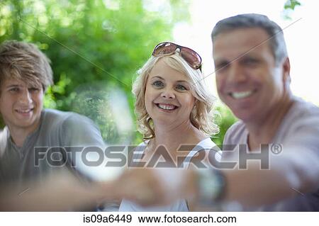 Stock Photo - Family at table together outdoors. Fotosearch