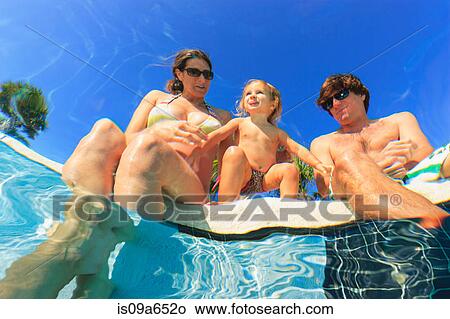 Picture - Family relaxing by swimming pool. Fotosearch