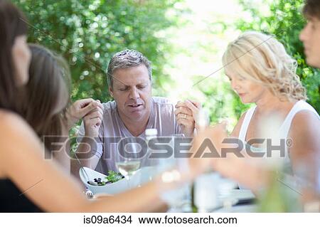 Family saying grace before eating View Large Photo Image Picture - Family saying grace before eating. Fotosearch